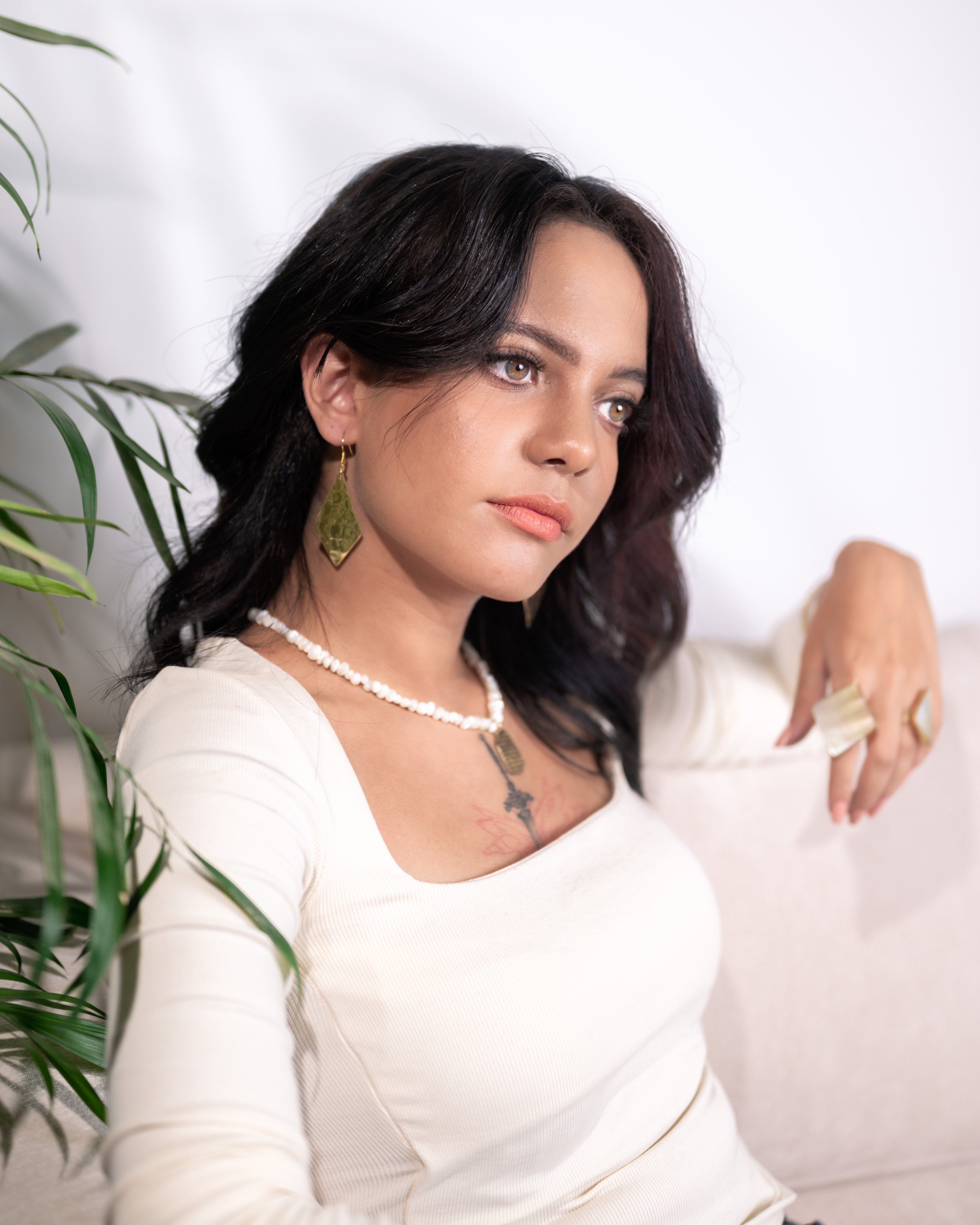 Portrait of model wearing contemporary Egyptian-inspired brass and seashell necklace