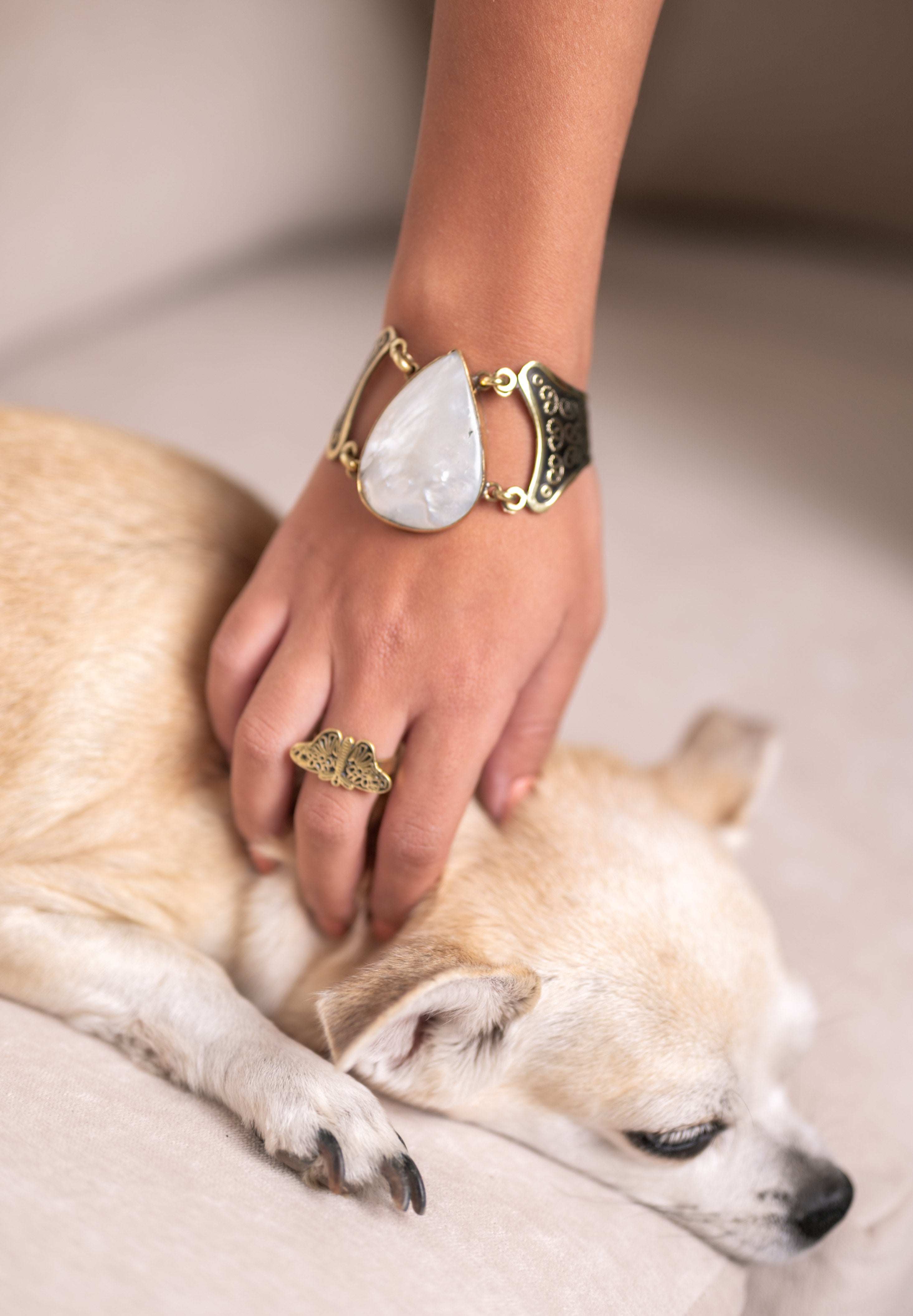 Model wearing Frasha adjustable brass butterfly ring on hand, showing scale and wing span on finger
